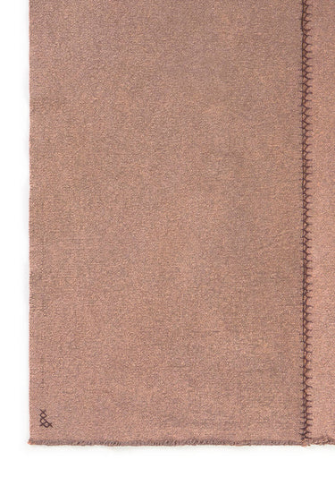 Detalle de las costuras de la alfombra artesanal marrón