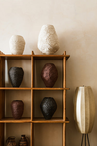 Jarrones Crochet blancos, granates y negros expuestos en una estantería de Matuta Home.