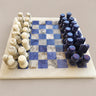 Ajedrez de casillas blancas y azules con figuras claras y azul violáceo.