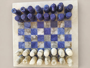 Vista cenital del tablero azul y blanco y las 32 figuras.