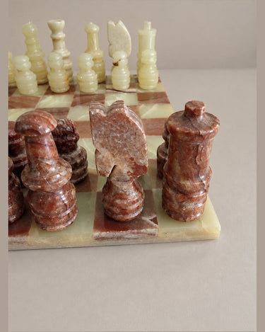 Caballo rojizo de perfil plano junto a otras figuras talladas.