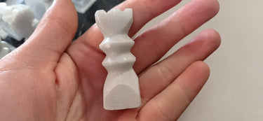 Figura blanca del ajedrez sostenida para mostrar su contorno.