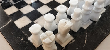 Figuras blancas alineadas junto al borde del tablero.