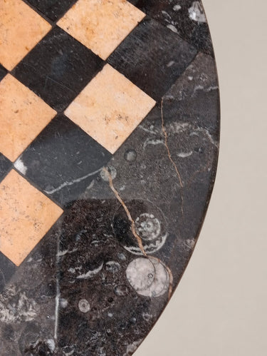 Detalle del canto del tablero de piedra, con vetas, fósiles y marcas superficiales.