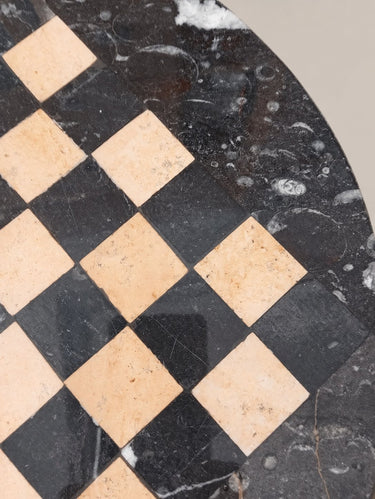 Detalle de casillas y borde del ajedrez de piedra, con arañazos y formas fósiles.