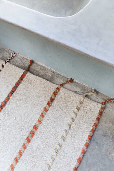 Detalle del tejido de algodón de una alfombra geométrica beige