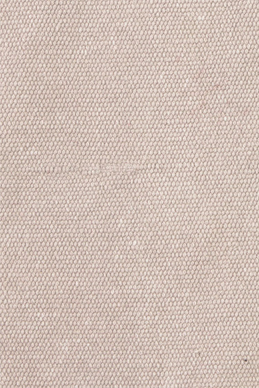 Detalle de las costuras visibles de una alfombra de algodón gris