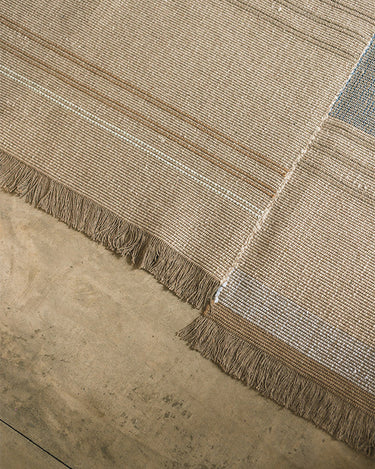 Alfombra artesanal de algodón y lino multicolor de Lorena Canals en dormitorio, formato 80 × 140 cm