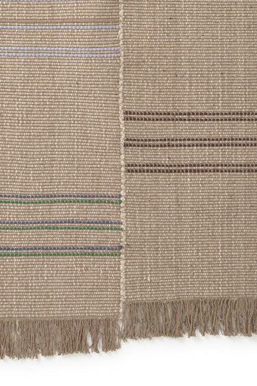 Detalle de los flecos de hilo reciclado de una alfombra de algodón y lino multicolor