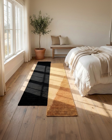 Alfombras de junco marino negra y ocre junto a la cama