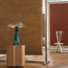 Yellow wool rug with a thick pile by Linie Design, hanging from a display frame beside a wooden pedestal