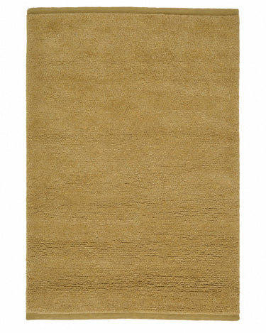 Yellow wool rug with a thick pile by Linie Design, full view of the rug with its woven edge