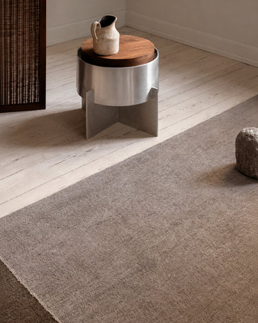 Hand-knotted moss green wool rug by Linie Design, surface detail beside a metal table