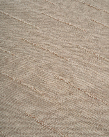 Beige wool rug with wavy lines by Linie Design, detail of the waves across the wool