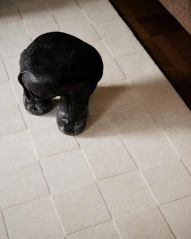 Luzern rugs by Linie Design: detail of the checks beneath a black object