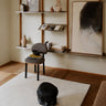 White wool rug with a raised check pattern by Linie Design, in a reading area with a striped chair