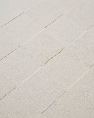 White wool rug with a raised check pattern by Linie Design, close-up of the different pile heights