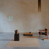 Tapis en laine terracotta à franges de Linie Design, à franges claires dans un salon aux tons terreux