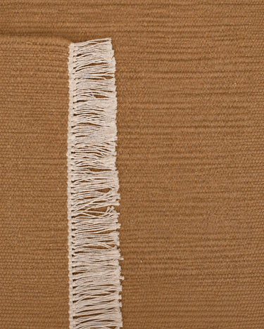 Tapis en laine terracotta à franges de Linie Design, détail d’une extrémité et de ses franges