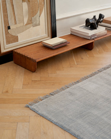 Alfombra Abyss Bliss de Linie Design, detalle de la alfombra junto a muebles bajos de madera