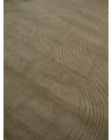 Alfombra irregular de lana verde oliva con surcos de Linie Design: detalle de las curvas recortadas.
