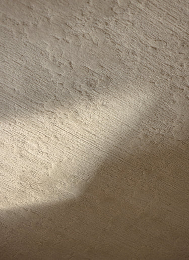 Alfombra irregular y redonda de lana beige Oceanic Reef de Linie Design, detalle de la superficie con luz y sombra