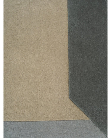 Alfombra de lana almendra con marco geométrico de Linie Design: vista cercana del borde oscuro.