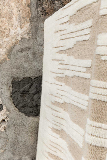 Textura artesanal de una alfombra lavable de lana arenisca y natural