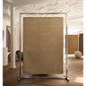 Alfombra de lana beige con borde ondulado de Linie Design: expuesta en un bastidor de madera.