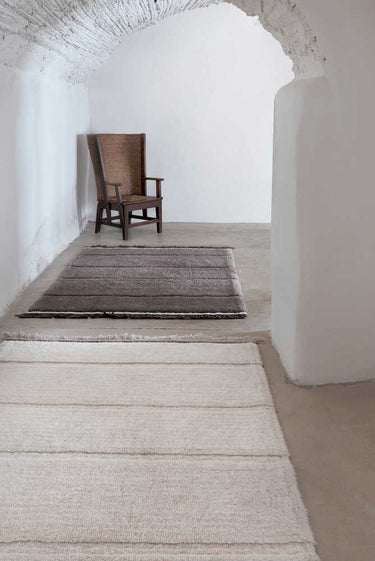 Alfombra de lana blanca con flecos de 80 × 140 cm en un interior sereno