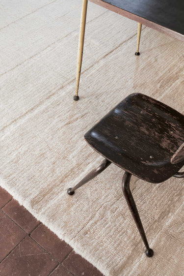 Detalle de los flecos de una alfombra lavable de lana blanca