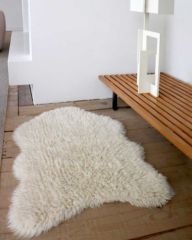 Detalle de la textura mullida de una alfombra de lana blanca con forma de piel