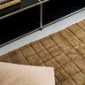 Alfombra lavable de lana geométrica ocre en salón cálido