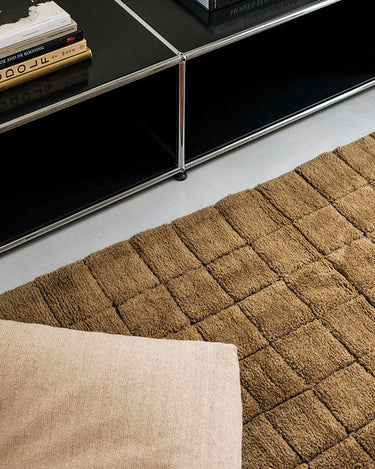 Alfombra lavable de lana geométrica ocre en salón cálido