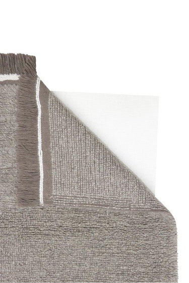Textura natural de lana gris de una alfombra lavable con flecos