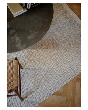 Alfombra de Linie Design: vista oblicua junto a la mesa.