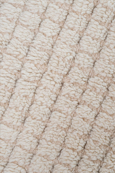 Textura artesanal de una alfombra lavable de lana natural y concha