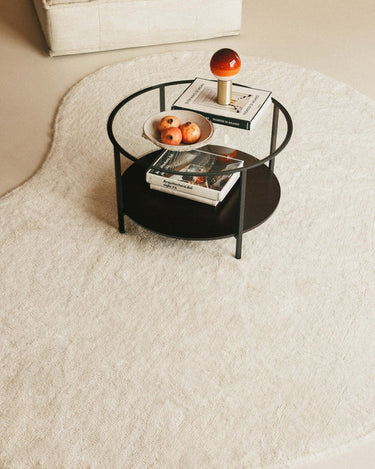 Alfombra lavable de lana orgánica natural con borde curvo en un salón sereno