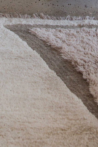 Detalle de las diferentes alturas de pelo de una alfombra de lana taupe