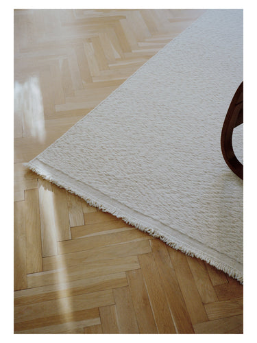 Alfombra de lana trenzada Blonde Maze de Linie Design, esquina sobre suelo de madera