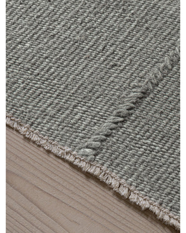 Alfombra de lino gris menta con líneas orgánicas de Linie Design: detalle del borde y los flecos cortos.
