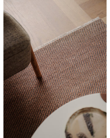 Alfombras de Linie Design: detalle junto a una mesa y un asiento.