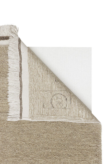 Detalle de los flecos de una alfombra lavable de lana beige para pasillo