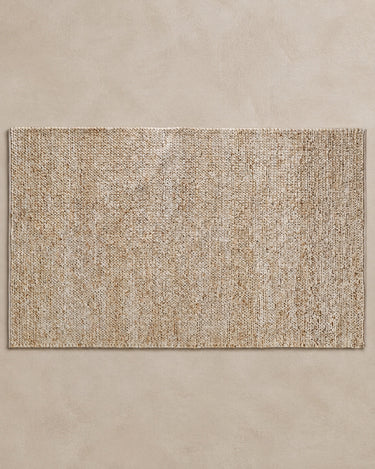 Alfombra de yute, algodón y fibra natural beige de Vical sobre superficie topo clara
