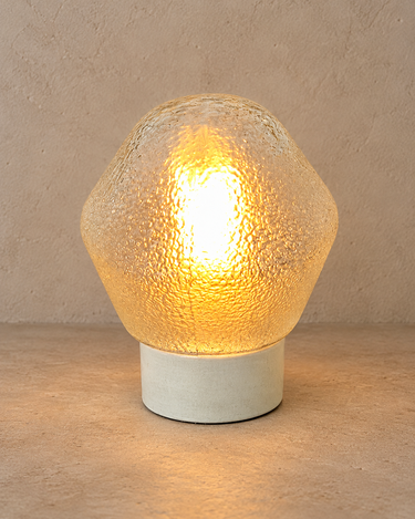 Aplique de pared de cerámica blanca y vidrio texturizado encendido con luz cálida