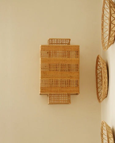 Aplique Ion de bambú en una pared beige con platos de fibras