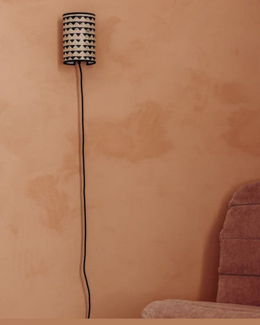 Aplique Joséphine B. Triangle negro · 12,5 × 18 cm de Le Monde Sauvage, instalado en una pared color terracota