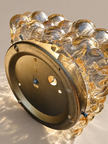 Detalle del soporte circular de metal dorado y de las fijaciones del aplique