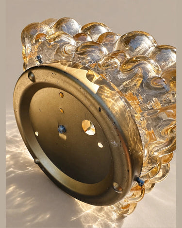 Detalle del soporte circular de metal dorado y de las fijaciones del aplique