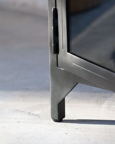Detalle del acabado de armario alto de metal negro con puertas de cristal de Tine K Home